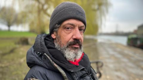 Man sitting by a river bank