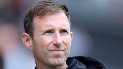 A headshot of Carlisle United head coach Mike Williamson 