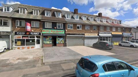 Several terraced shops on a street.
