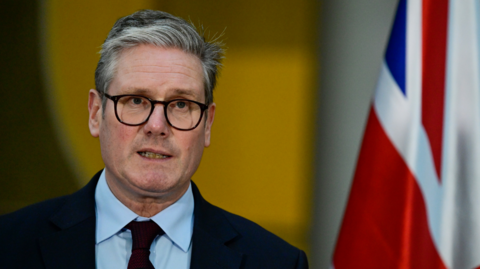 Keir Starmer standing in front of a Union Jack