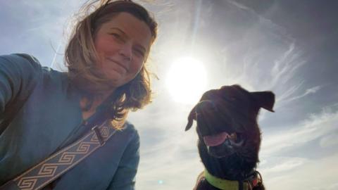Marieke Pepers and her pet dog with a low sun behind them