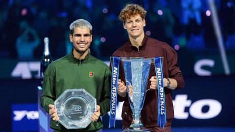 Carlos Alcaraz (left) and Jannik Sinner (right) pose as they hold trophies