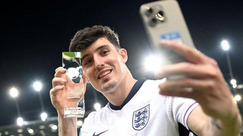 Tino Livramento takes a selfie while holding his player-of-the-match award