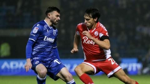 Gillingham's Jonny Smith in action with Crawley Town's Josh Flint.