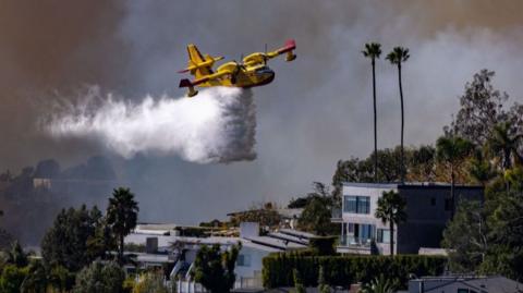 Plane drops water on the Palisades fire on 7 January 2025 