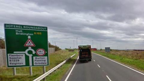 A google street view image of the A165. To the left of the road is a green road sign directing people to Hull, Bridlington, Speeton and Flamborough.