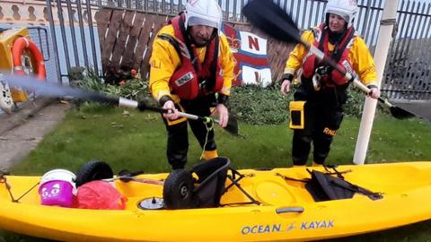 RNLI volunteers with fishing kayak