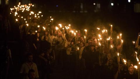 Neo-Nazis, alt-right, and white supremacists brandish torches during a night-time march