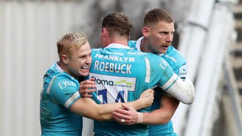 Arron Reed and Tom Roebuck hug Rob du Preez following his try