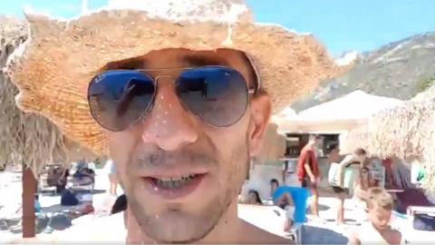 Adam Catzavelos on a beach