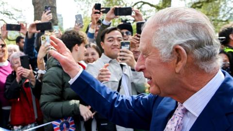 King Charles waves to people outside the Mall