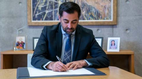 Humza Yousaf signs his official resignation letter to King Charles III at the Scottish Parliament in Edinburgh