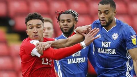 Curtis Nelson of Cardiff and Jacob Brown of Barnsley challenge for the ball