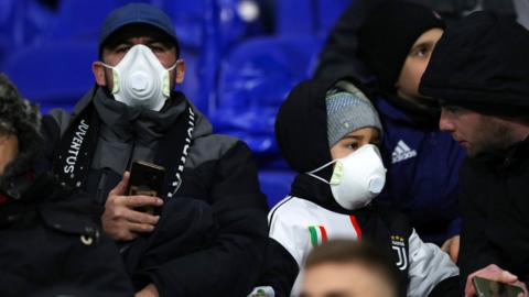 Two Juventus supporters wearing face masks to guard against coronavirus