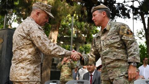 The generals shake hands during a ceremony