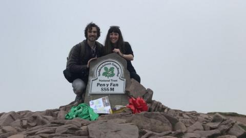 Photo of a couple with the sign