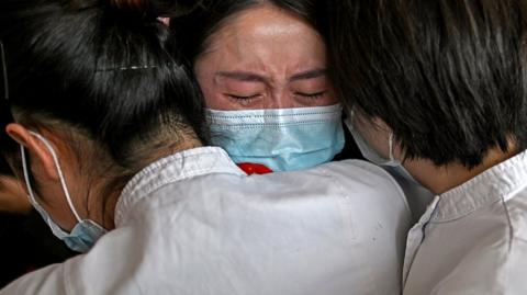 Medical staff hug nurses