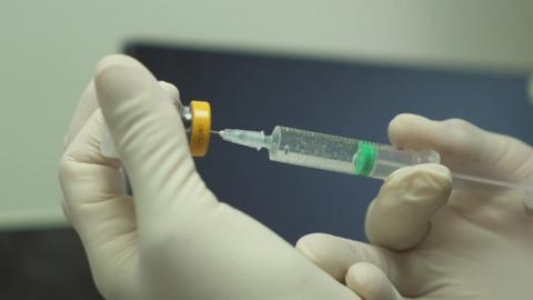 A syringe being filled