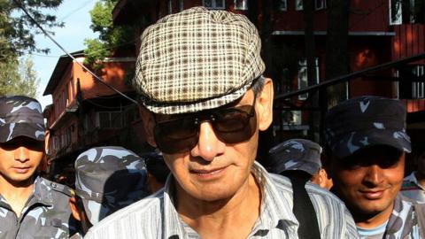 French serial killer Charles Sobhraj (C) is guided by Nepalese policemen towards a waiting vehicle after a court hearing in Kathmandu on May 31, 2011