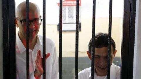 British-Canadian teacher Neil Bantleman (left) and Indonesian teaching assistant Ferdinand Tjiong inside a holding cell before their trial at a South Jakarta court (02 April 2015)