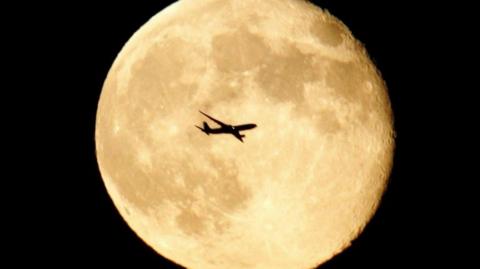 Aircraft in front of moon