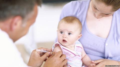 A doctor vaccinates a 4-month-old baby girl