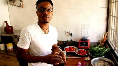 Nigerian chef Michael Elegbede with stockfish, tomatoes, peppers and other ingredients for efo riro