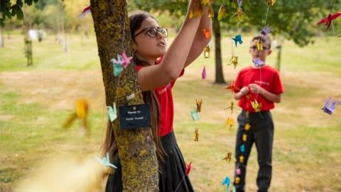 Children hang origami peace crane