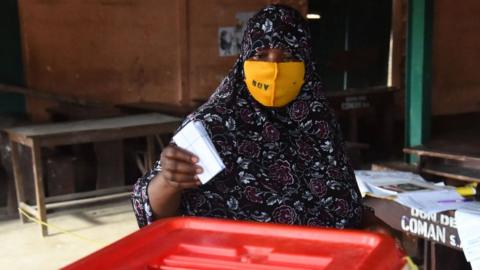 A voter casts her ballot at a polling station during the Benin Presidential election in Cotonou on April 11, 2021.