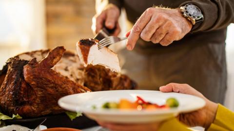 Older man serving cooked turkey