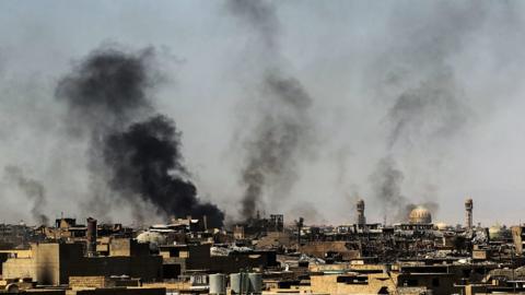 Smoke billows as Iraqi forces advance through the Old City of Mosul