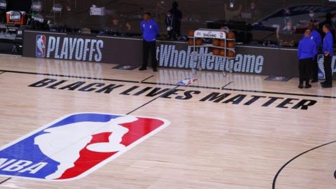 Referees on an empty court after the Milwaukee Bucks boycott an NBA play-off game