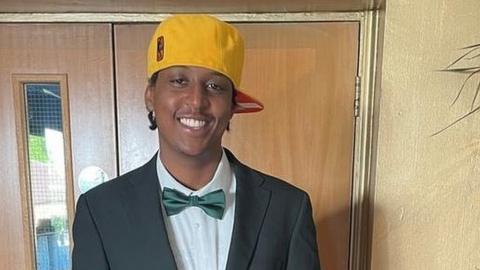 Eddie Kinuthia smiling in a bowtie and yellow cap