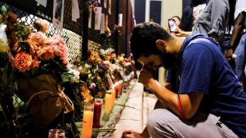 People hang signs of missing residents near the site of the Miami building collapse