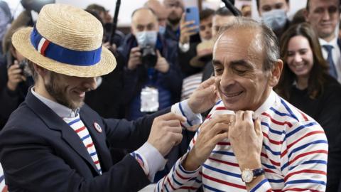 French far-right polemicist Eric Zemmour tries on a striped shirt as he visits the "Made In France" expo at the Porte de Versailles exhibition hall in Paris, France, 14 November 2021