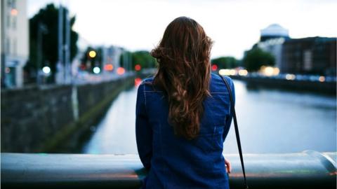 Woman looking from bridge