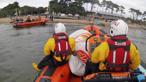 Cowes lifeboat approaches Calshot lifeboat on Lepe beach