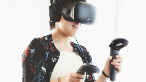 A woman using a virtual reality headset and controllers