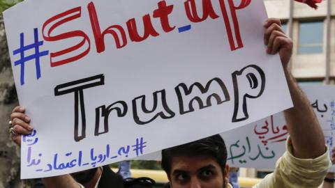 Iranian man holds up a banner saying: #Shut_up Trump" at a protest outside the former US embassy in Tehran on 9 May 2018