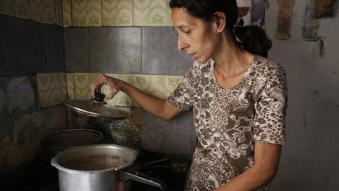 Woman inspects pot amid shortages of food in Venezuela