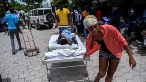 A woman injured in Saturday"s 7.2 magnitude quake is transported on a hospital bed to a hospital, in Les Cayes, Haiti August 16, 2021.