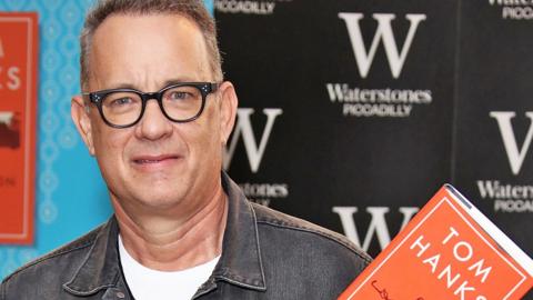 Archive image of Tom Hanks holding one of his books at an event in London