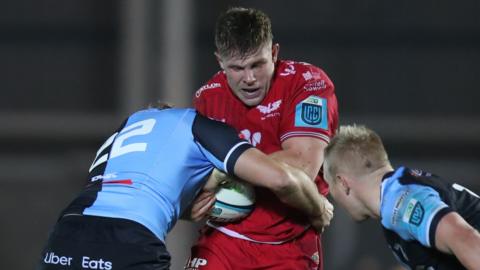 Teddy Leatherbarrow is tackled by two Cardiff defenders