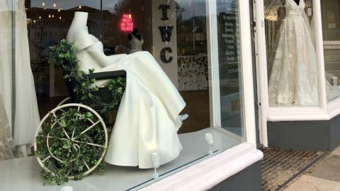 The White Collection displays a gown on a mannequin in a wheelchair in its store in North Somerset