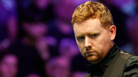 Ben Woollaston looks across the snooker table as he contemplates a shot