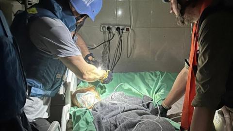UN medics attend to a critically ill Palestinian at Nasser hospital in Khan Younis during a mission to transfer patients to other hospitals in Gaza