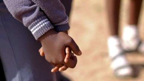 Two schoolgirls hold hands in Nigeria - archive shot