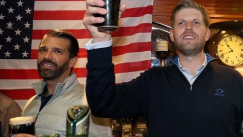 Donald Trump Jr. (centre), and Eric Trump (right), the sons of US President Donald Trump, behind the bar in Tubridy"s Bar in the village of Doonbeg, Co Clare, on the first day of US President Donald Trump"s visit to the Republic of Ireland