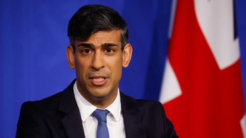 Rishi Sunak stands infront of a union flag while delivering a press conference on 22 April