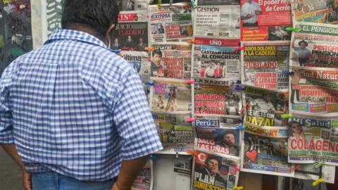 A man reads the headlines in the centre of Lima, 23 April, 2022